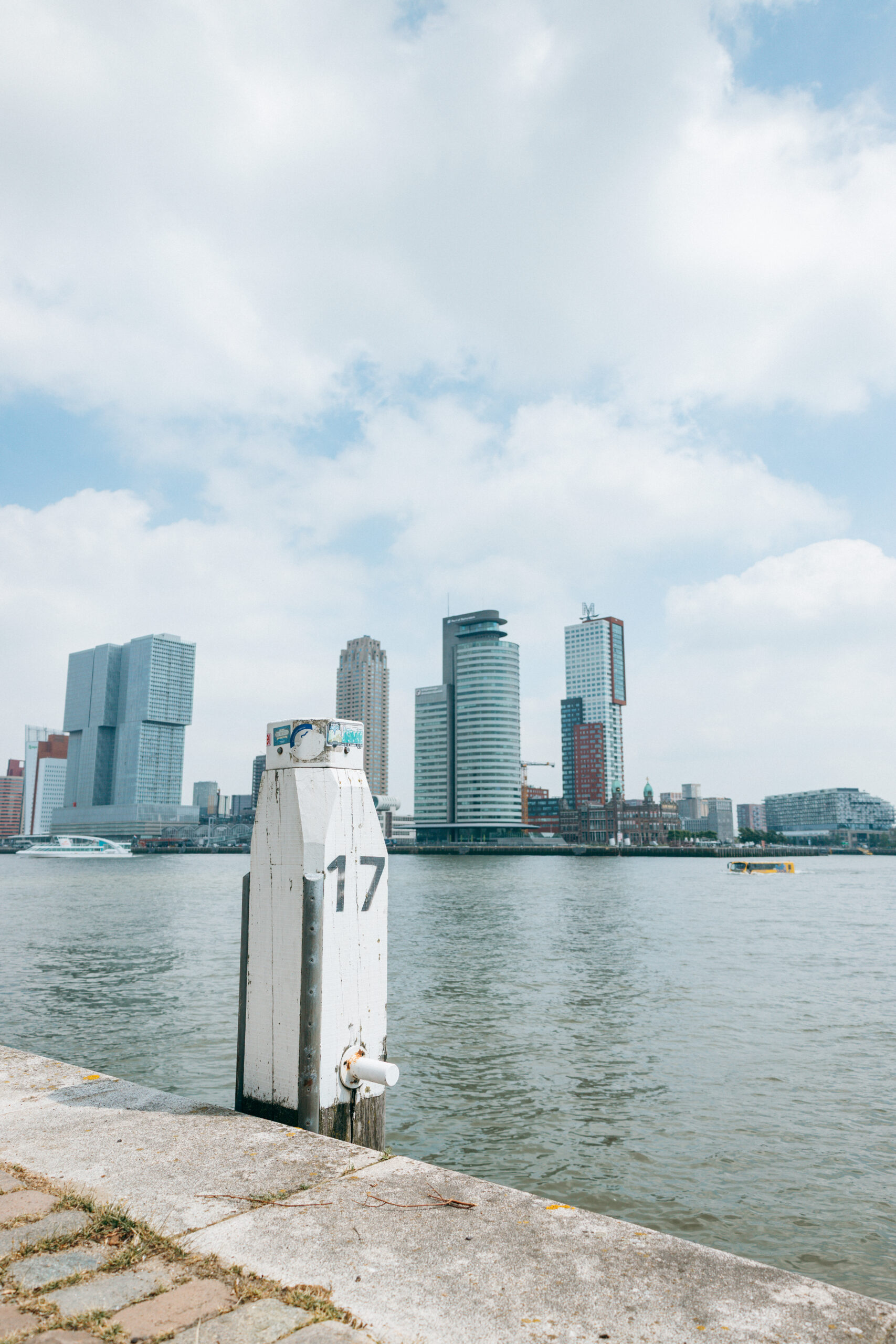 Skyline von Rotterdam an der Nieuwe Maas mit Pollern im Vordergrund