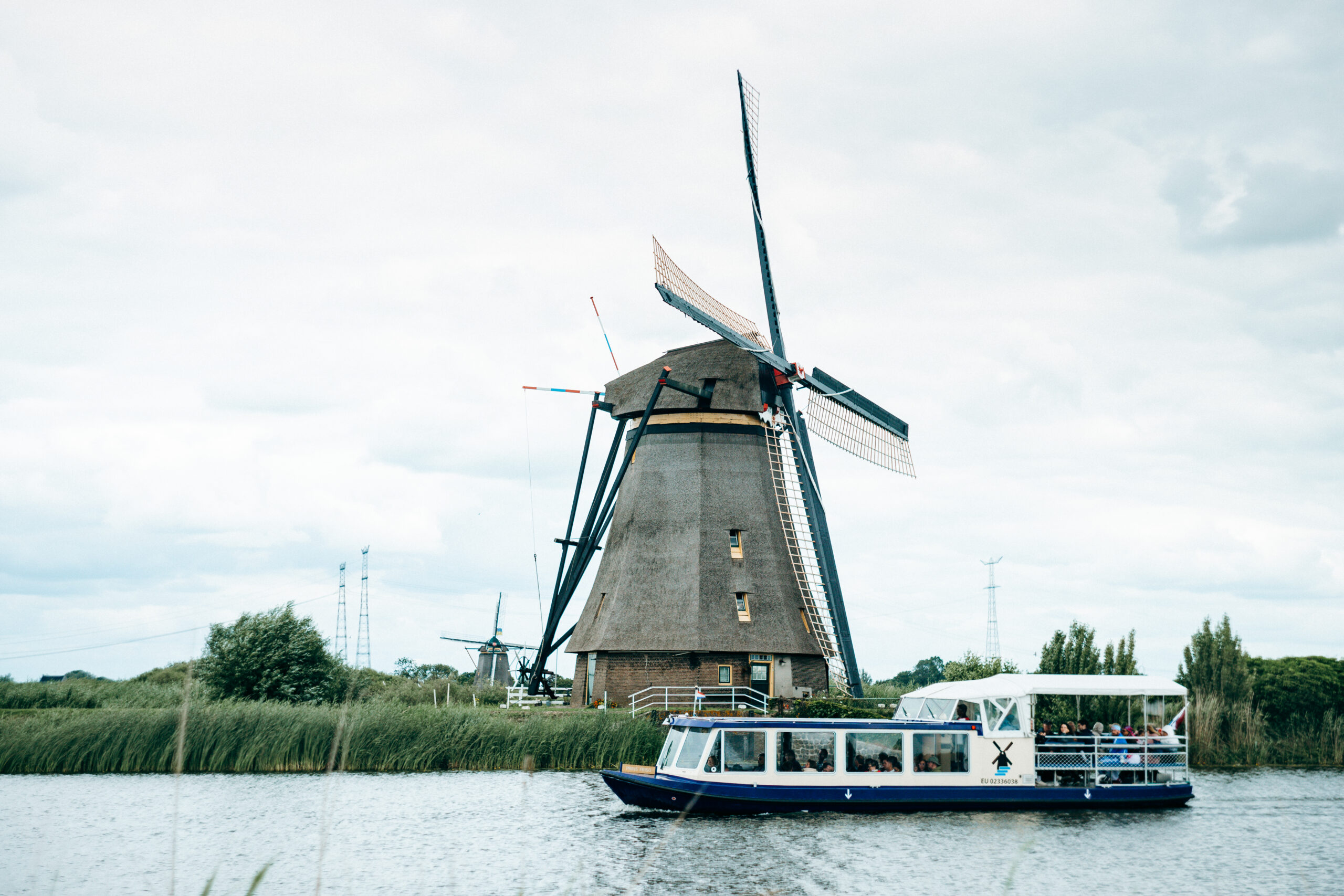 Ausflugsboot vor einer Windmühle in Kinderdijk