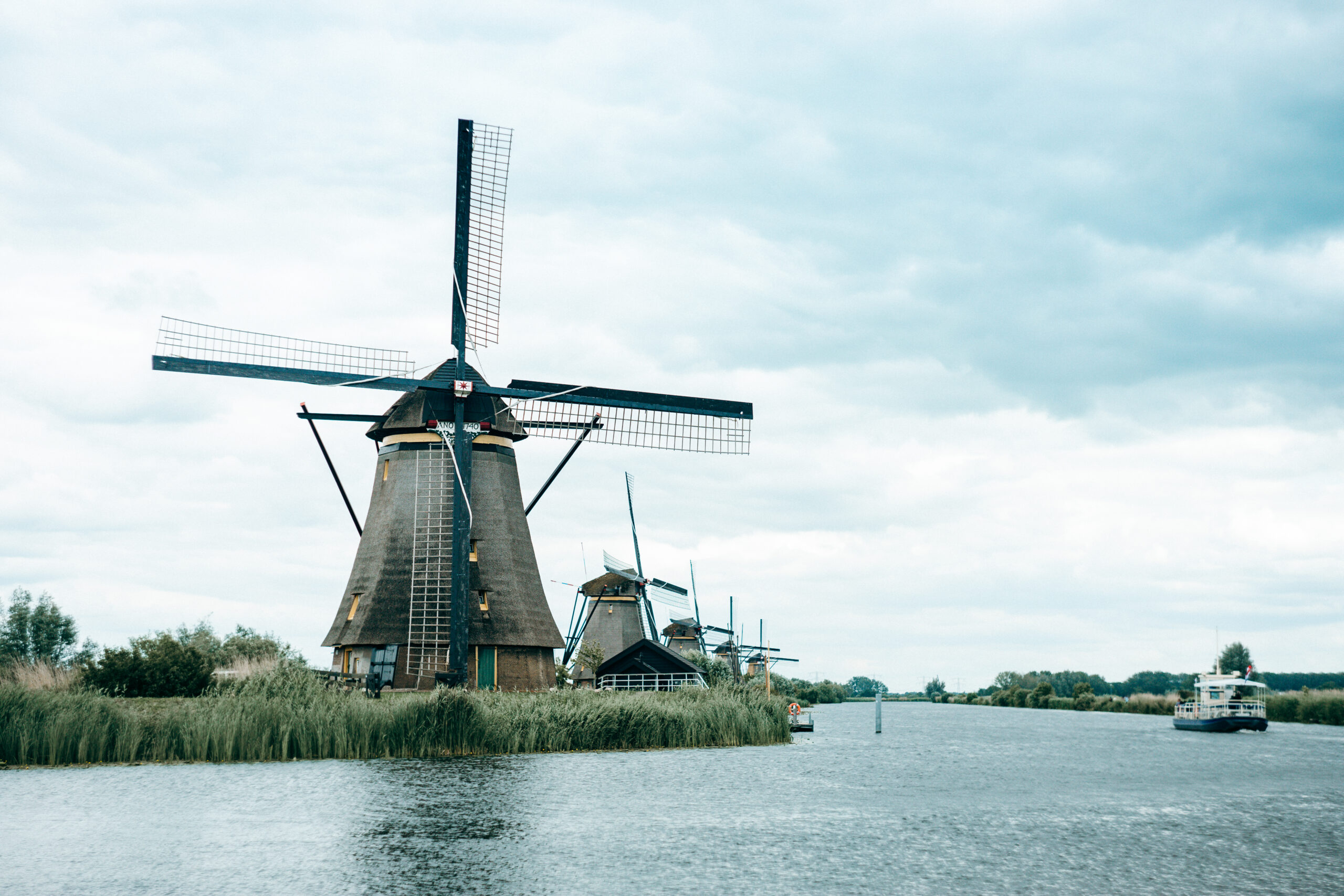 Historische Windmühlen am Wasser in Kinderdijk mit einem Boot